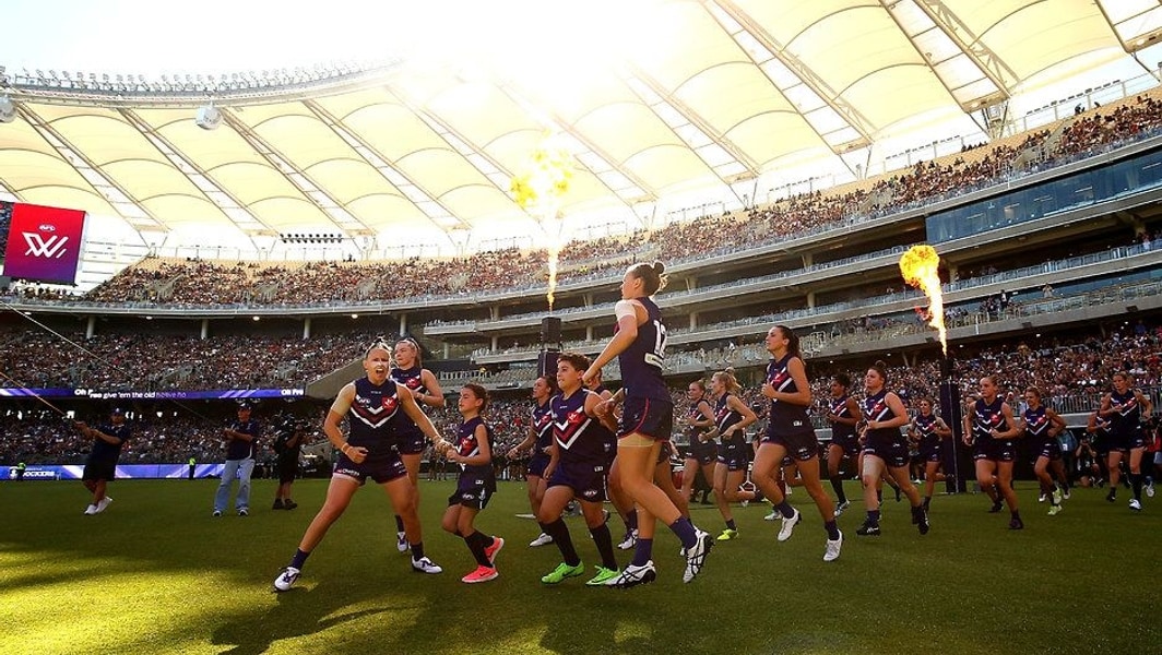 Packed crowd at Optus Stadium during an AFL night match in Perth.