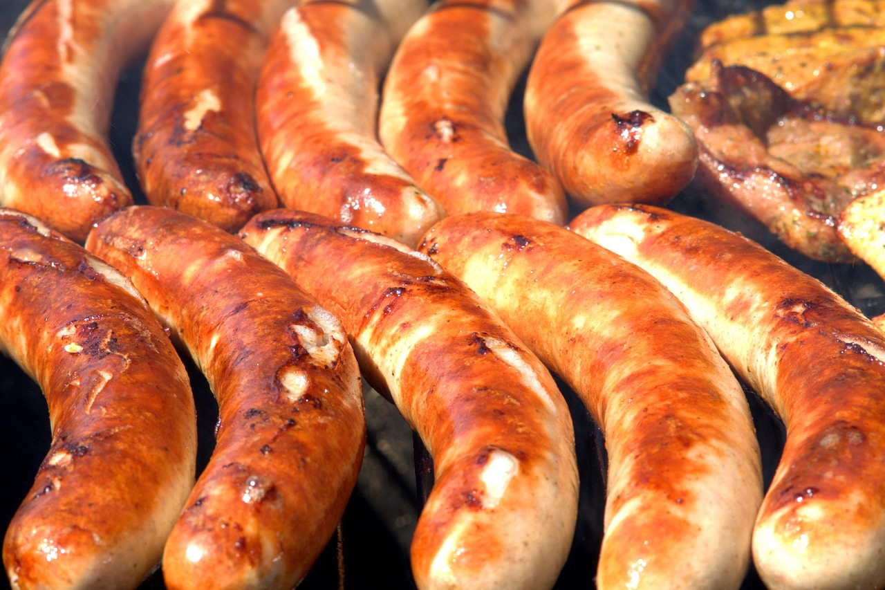 Sausages grilling on a barbecue for a community footy fundraiser.