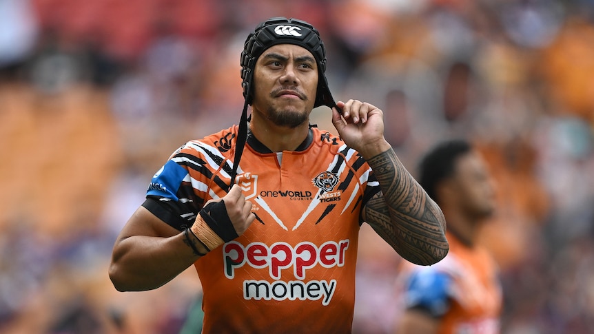 Jarome Luai of the Wests Tigers adjusts his head gear