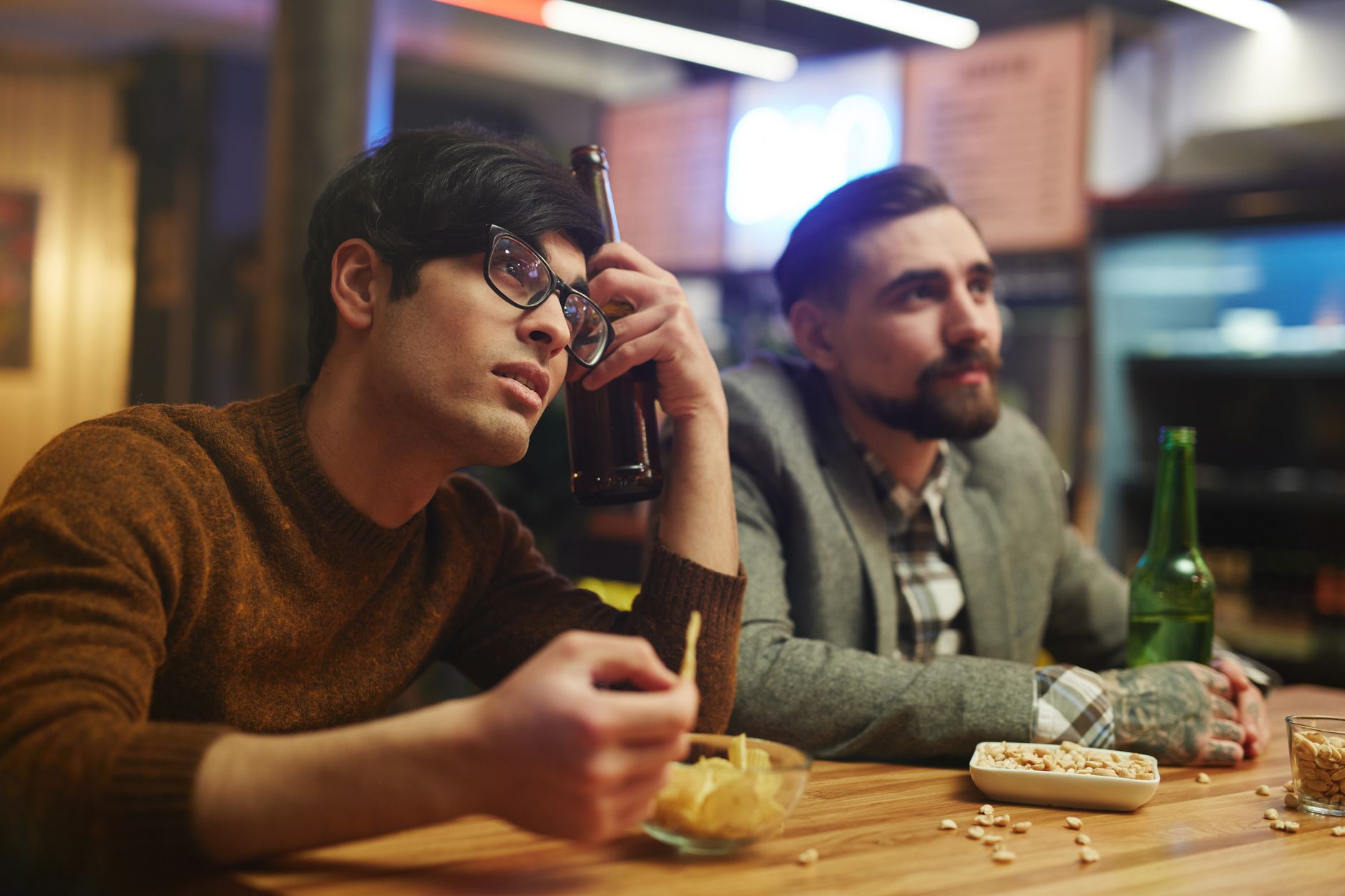 Mates watching sport in a pub, where venue subscription bills usually climb before home streaming prices do