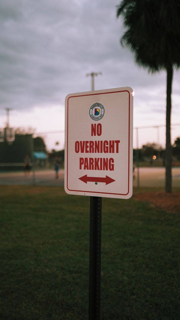No Overnight Parking sign in a public park, echoing tighter overnight vehicle restrictions.