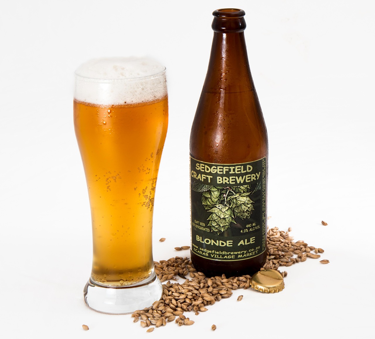 Bottle and glass of amber craft beer on a brewery table