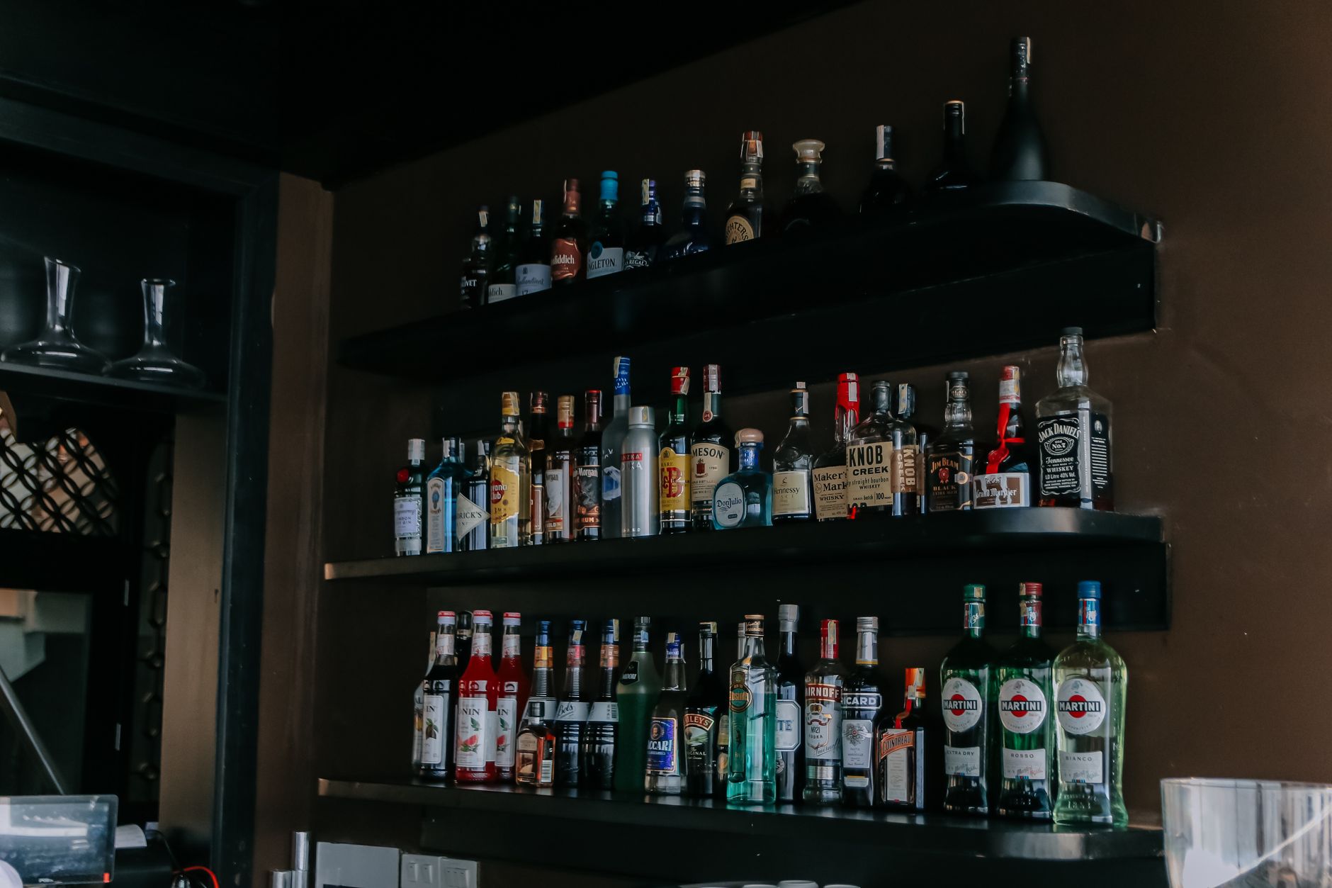 Rows of sealed spirits lined up on a back-bar shelf