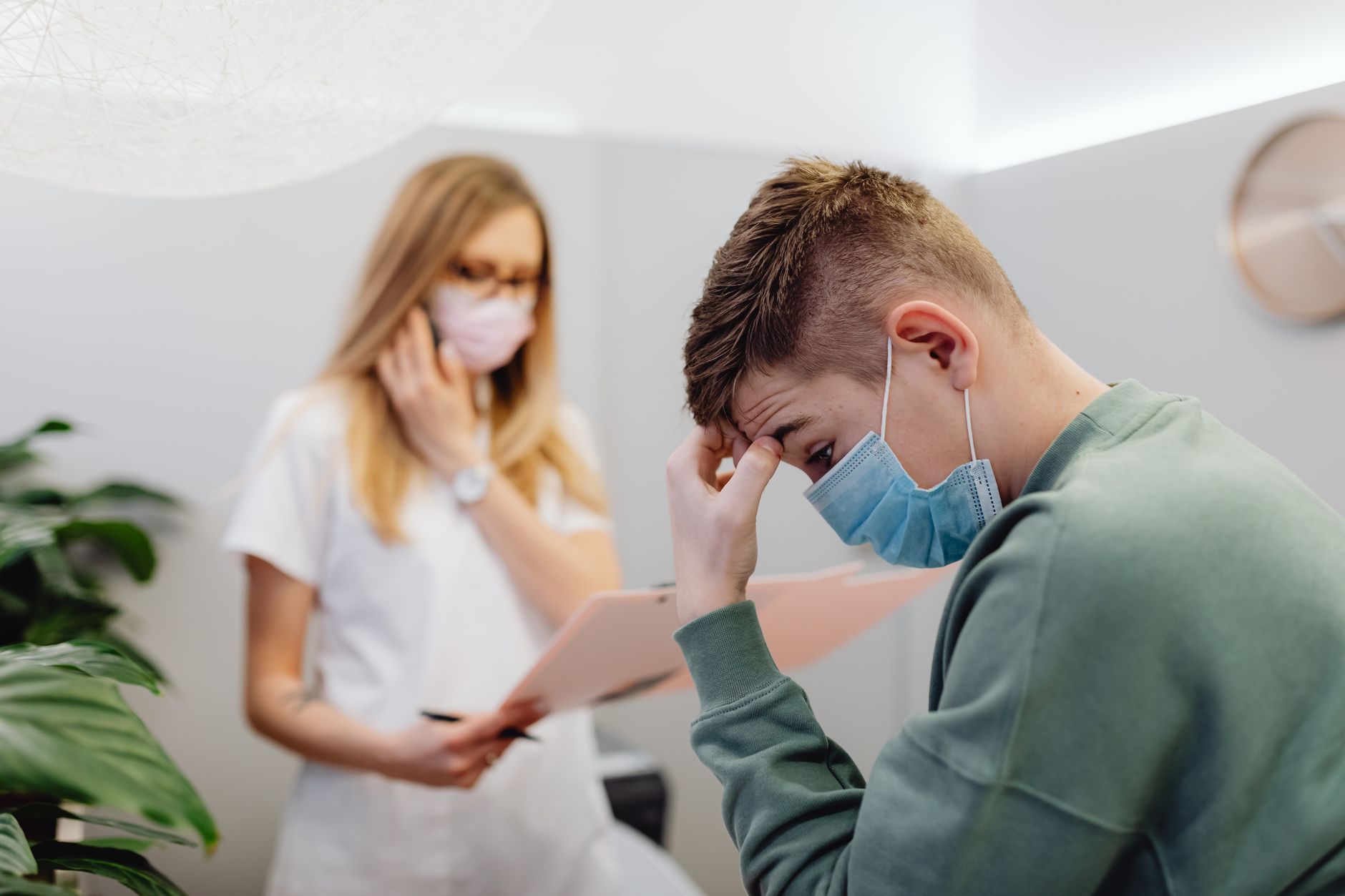 A worried patient speaks with a healthcare professional in a medical office.