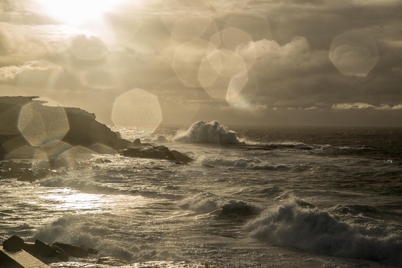 Rough sea and rain hitting an Australian coastal shoreline under stormy skies