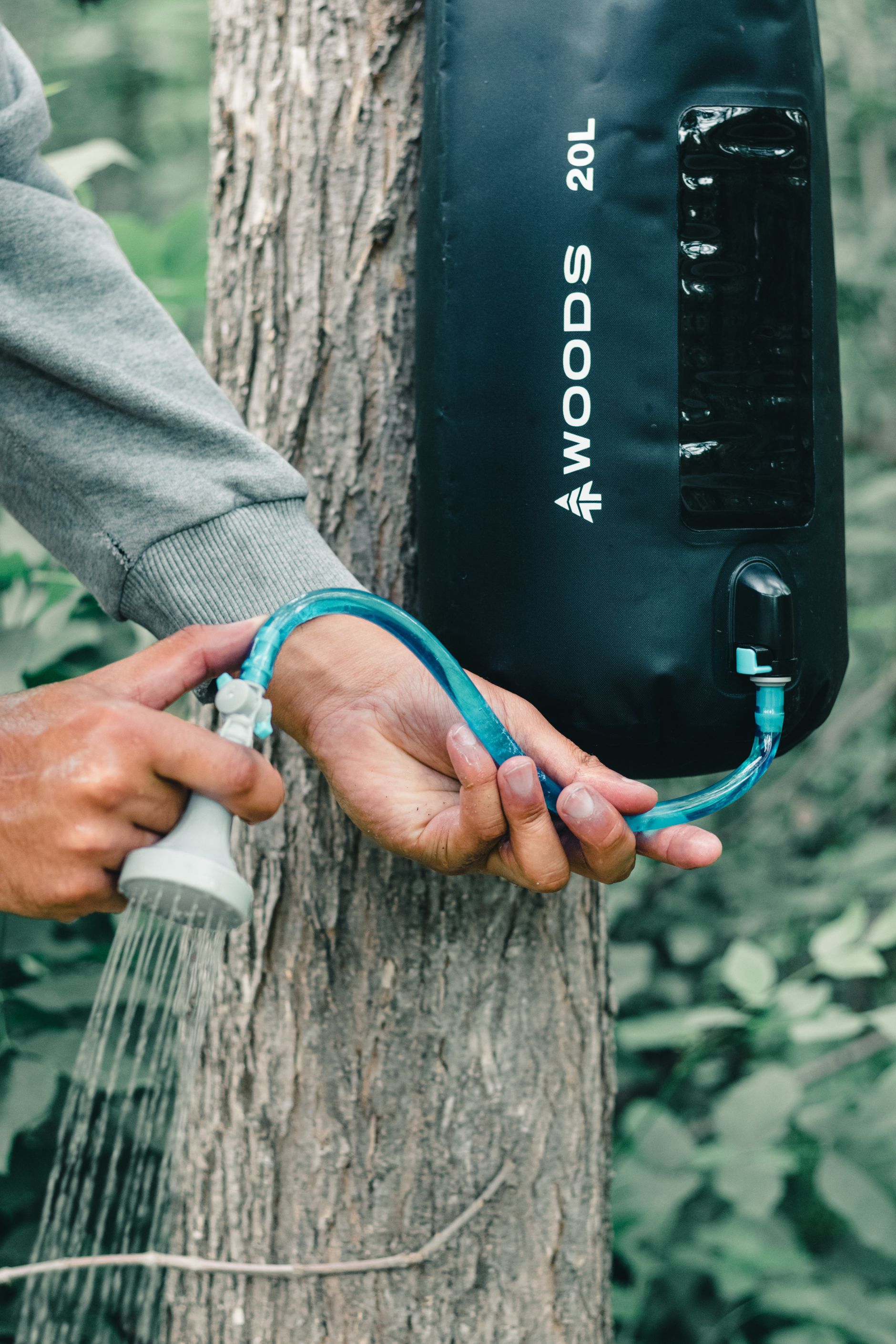 Portable shower bag hanging beside a bush campsite