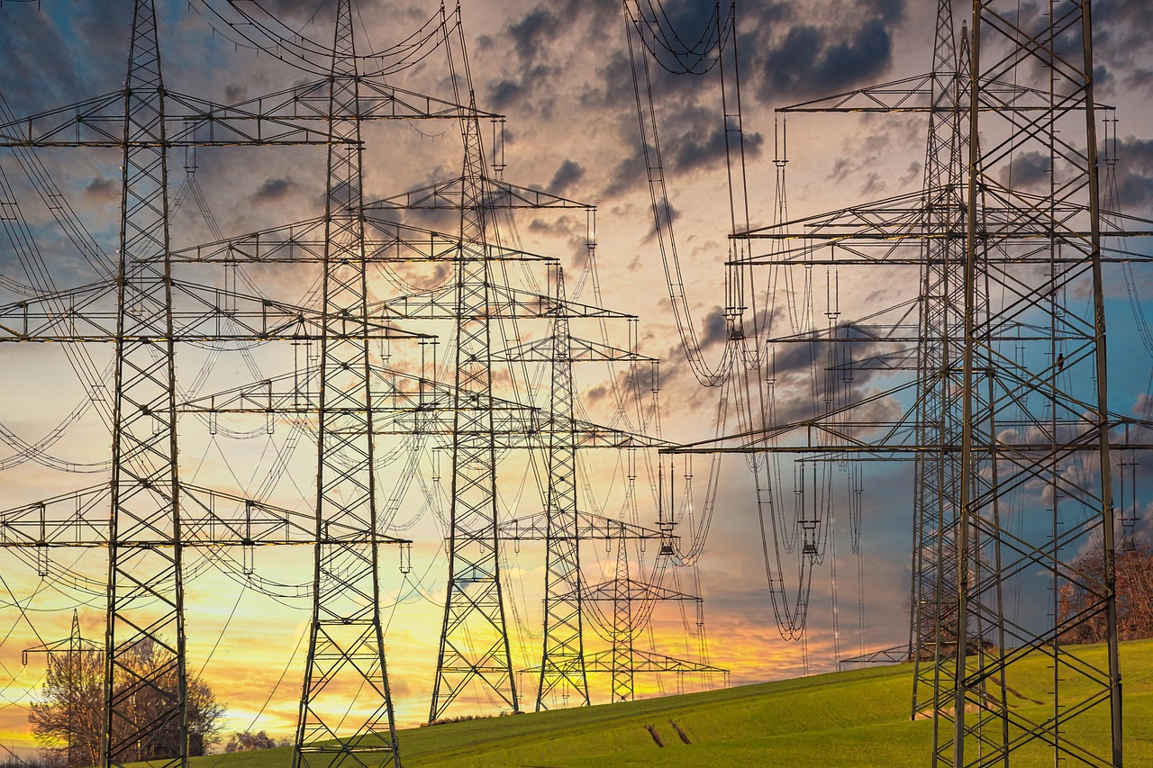 Electricity pylons and high-voltage power lines at sunset