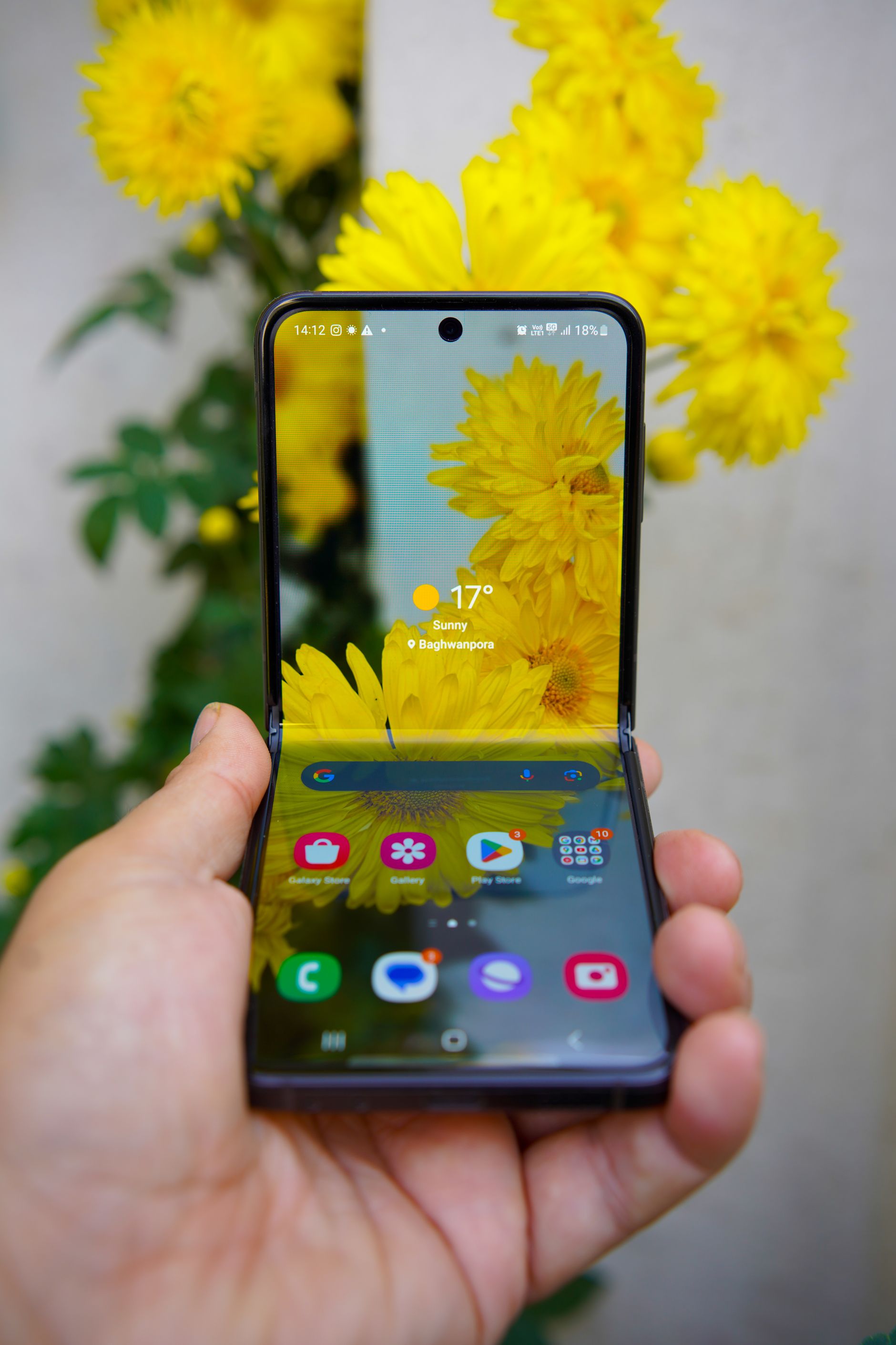 Hand holding a foldable smartphone outdoors