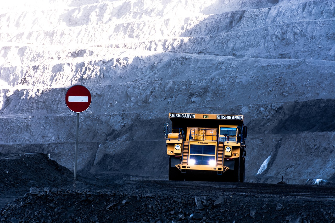 Large haul truck at a coal mining site under a clear sky.